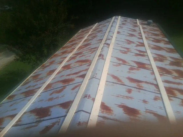 Rusted metal roof panels with new wood purlins before replacement — Storm Damage Roof Repair in Chantilly by Roofing Brothers