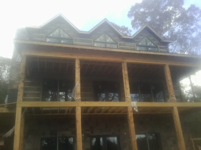 Dormers and porch framing on a large log home under construction — Roof Coating work by our crew in Chantilly