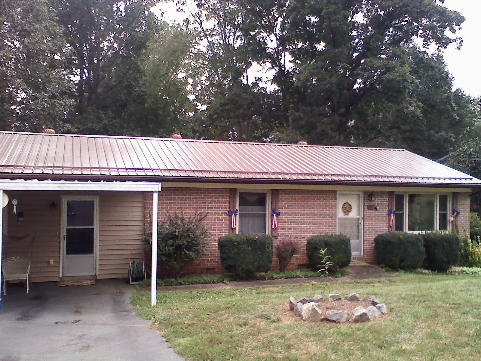 Bronze metal roof and carport on a brick ranch home — Roof Repair work by our crew in Chantilly